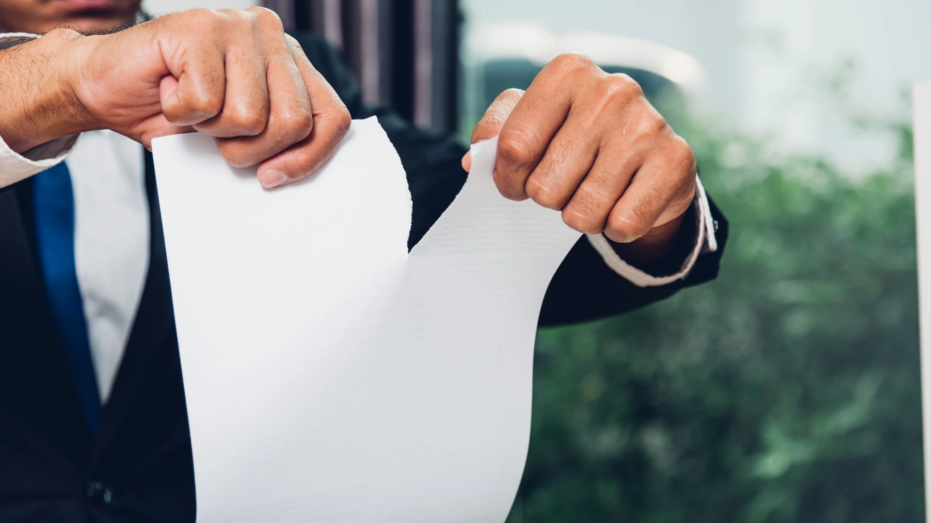 hand tearing a document paper