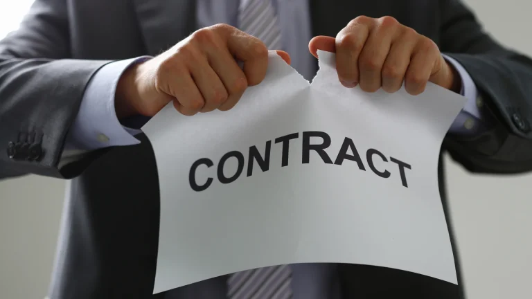 man tearing paper with text contract in it because of financial red flags