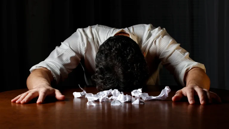 Man face down on table with crampled papers thinking about how to sell your business
