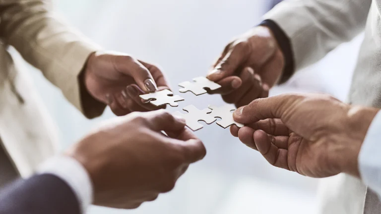 4 people holding puzzle piece each showing distressed exit strategy building