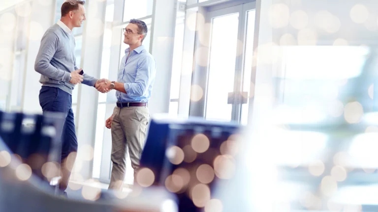 2 guys shaking hands showing partnership strategy for distressed exit
